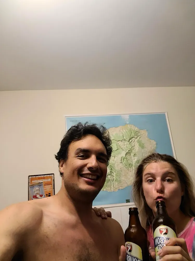 Fabien et Pamela avec des bières Bourbon, devant une carte en relief de La Réunion.