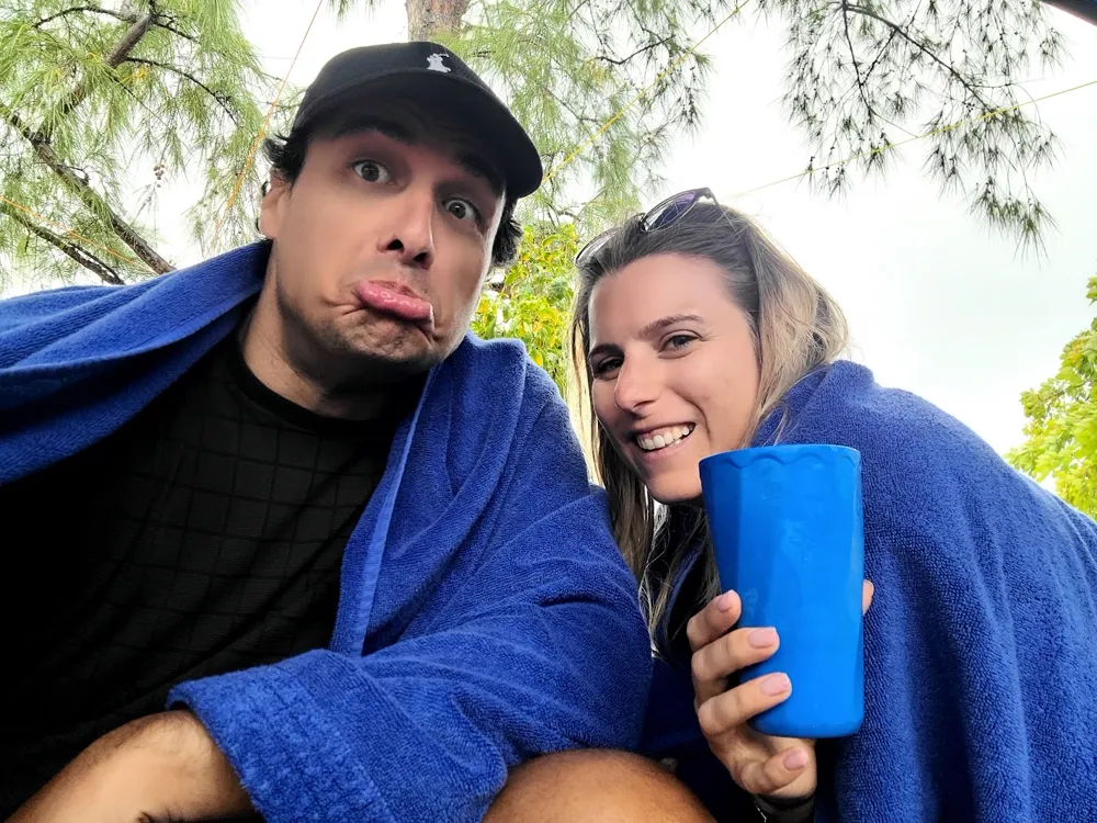 Fabien et Pamela enroulés dans des serviettes bleues, grimaces face à l'appareil.